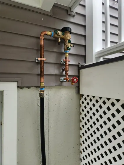 Backflow preventer installed on an outside wall