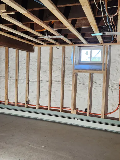 Baseboard heating piped in a basement under renovation