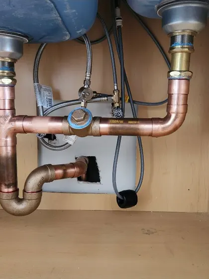 Copper drain and supply piping under a double kitchen sink